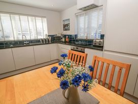 A kitchen with wooden table and flowers at Fistral Palms 2 Newquay