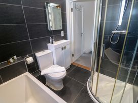 A bathroom with a bathtub, toilet, sink, and shower at Fistral Palms 2 in Newquay