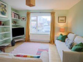 A living room with a television and bookshelves at 20 Lym Close