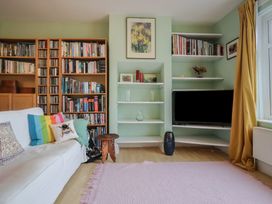 A living room with a bookshelf and a television at 20 Lym Close