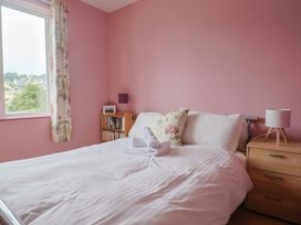 A bedroom with a bed and bookshelf at 20 Lym Close in Lyme Regis