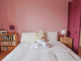 A bedroom with a bed and bookshelf at 20 Lym Close, Lyme Regis