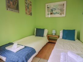 A bedroom with two beds and a nightstand at 20 Lym Close Lyme Regis