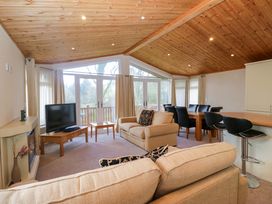 A living room with a television and sofa at Wansfell 2 in Limefitt Park near Troutbeck