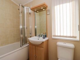 A bathroom with a bathtub, shower, sink, and toilet at Wansfell 2 Limefitt Park near Troutbeck