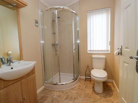 A bathroom featuring a shower, toilet, and sink at Wansfell 2 Limefitt Park near Troutbeck
