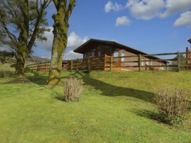 A house with a wooden fence and trees at Wansfell 2 in Limefitt Park near Troutbeck