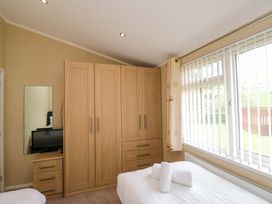A bedroom with a wardrobe and television at Wansfell 2 Limefitt Park near Troutbeck