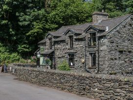 A stone building with windows and flower pots at Wally's Folly in Limefitt Park near Troutbeck