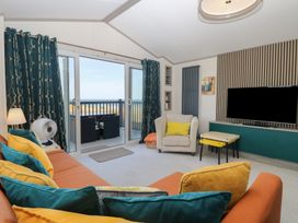 A living room with furniture and a television at Sand & Serenity in Bacton