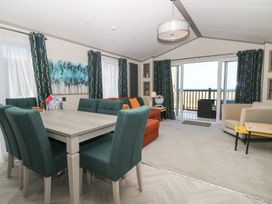 A living room with a table and chairs at Sand & Serenity in Bacton