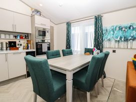 A dining room with a table and chairs at Sand & Serenity in Bacton