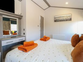 A bedroom with a bed and orange towels at Sand & Serenity in Bacton