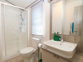 A bathroom with a shower, toilet, and sink at Sand & Serenity in Bacton