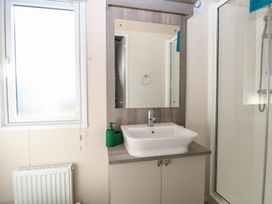 A bathroom with a sink and mirror at Sand & Serenity in Bacton