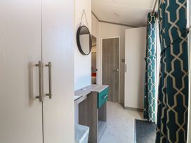 A hallway with a table and wardrobe at Sand & Serenity in Bacton