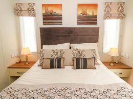 A bedroom with a bed and lamps at Ty Seren in New Quay