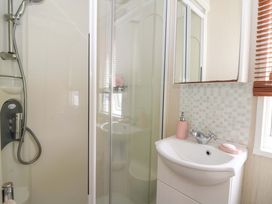A bathroom with a shower and sink at Ty Seren New Quay