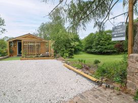 A cabin with a gravel path and lawn at Stoney Rock Lodge
