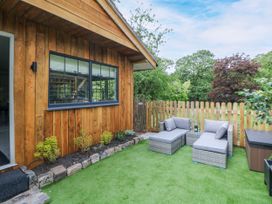 A garden with lounge chairs and a wooden wall at Stoney Rock Lodge