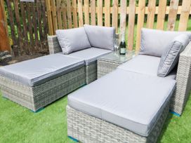 An outdoor seating area with sofa and glass table at Stoney Rock Lodge