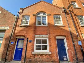 A red brick building with blue doors and white framed windows at Old Malthouse Apartment in Weymouth
