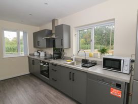 A kitchen with sink, oven, microwave and windows at Glandwr House Crossgates near Llandrindod Wells