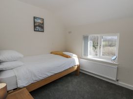 A bedroom with a bed and window at Glandwr House in Crossgates near Llandrindod Wells