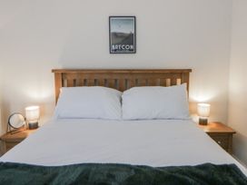 A bedroom with a bed, bedside tables and lamps at Glandwr House in Crossgates near Llandrindod Wells