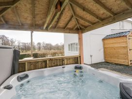 A hot tub under a wooden structure at Glandwr House in Crossgates near Llandrindod Wells