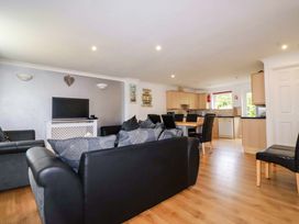A living room with a sofa and television at Sea Thrift White Cross near Indian Queens