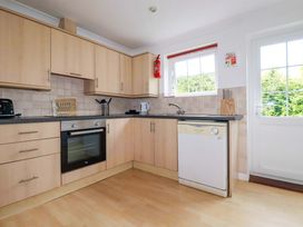 A kitchen with cabinets and appliances at Sea Thrift in White Cross near Indian Queens