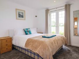 A bedroom with a bed and a nightstand at Sea Thrift in White Cross near Indian Queens
