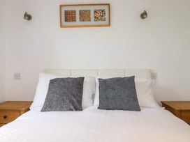 A bed with pillows and nightstands at Sea Thrift near Indian Queens
