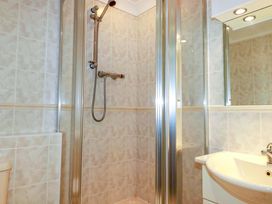A bathroom with a shower and sink at Sea Thrift in White Cross near Indian Queens