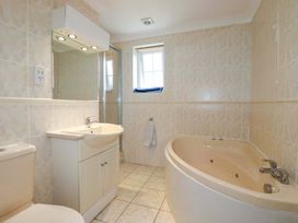 A bathroom with a sink, toilet, shower, and bathtub at Sea Thrift in White Cross near Indian Queens