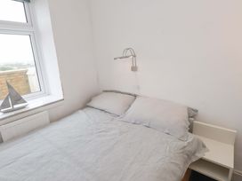 A bedroom with a bed and pillows at Sea Views No 8 Plas Darien Trearddur Bay