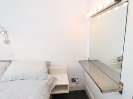 A bedroom with a bed and a mirror at Sea Views No 8 Plas Darien Trearddur Bay