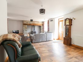 A living room with an armchair and sofa at Gwernffridd