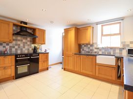 A kitchen with cabinets and sink at Gwernffridd 