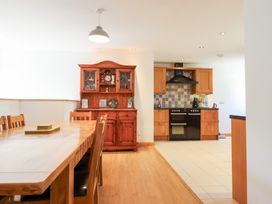 A kitchen with dining table and sideboard at Gwernffridd