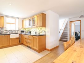 A kitchen with wooden cabinets and appliances at Gwernffridd