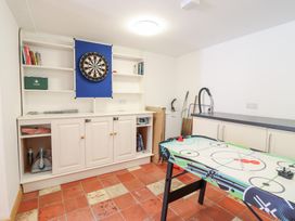 A games room with a dartboard and air hockey table at Gwernffridd