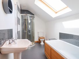 A bathroom with a sink, shower, bathtub, and toilet at Gwernffridd