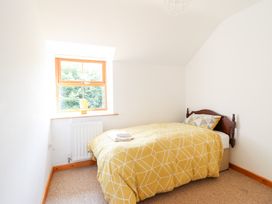 A bedroom with a bed and window at Gwernffridd