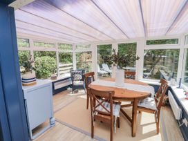 A conservatory with a table and chairs at 1 Island View Thurlestone