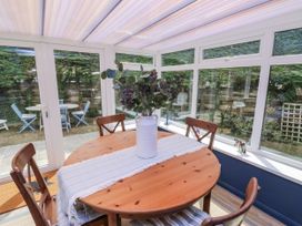 A table with chairs and a vase in a conservatory at 1 Island View Thurlestone