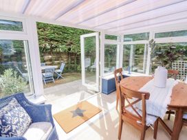 A dining area with a table and chairs in a conservatory at 1 Island View Thurlestone