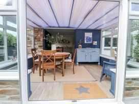 A dining area with a table and chairs at 1 Island View in Thurlestone