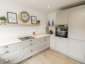 A kitchen with grey cabinets and modern appliances at 1 Island View in Thurlestone